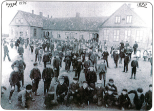 Skolbarn framför Östra Skolan år 1890. Skolan uppfördes som folkskola 1876. Eslöv var vid denna tidpunkt en köping och skolan omnämndes vid uppförandet som Köpingeskolan.
